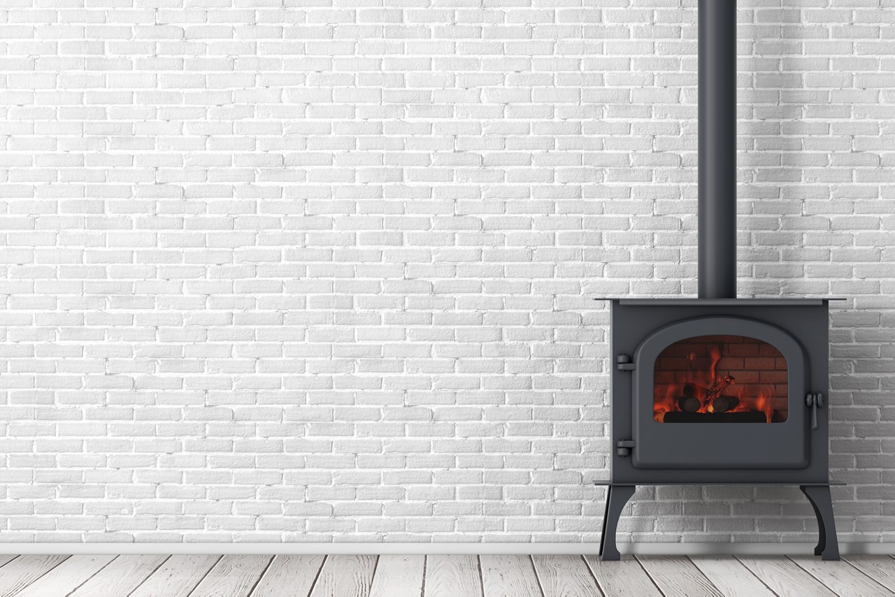 Classic Ð pen Home Fireplace Stove with Chimney Pipe and Firewood Burning in Red Hot Flame in front of brick wall. 3d Rendering