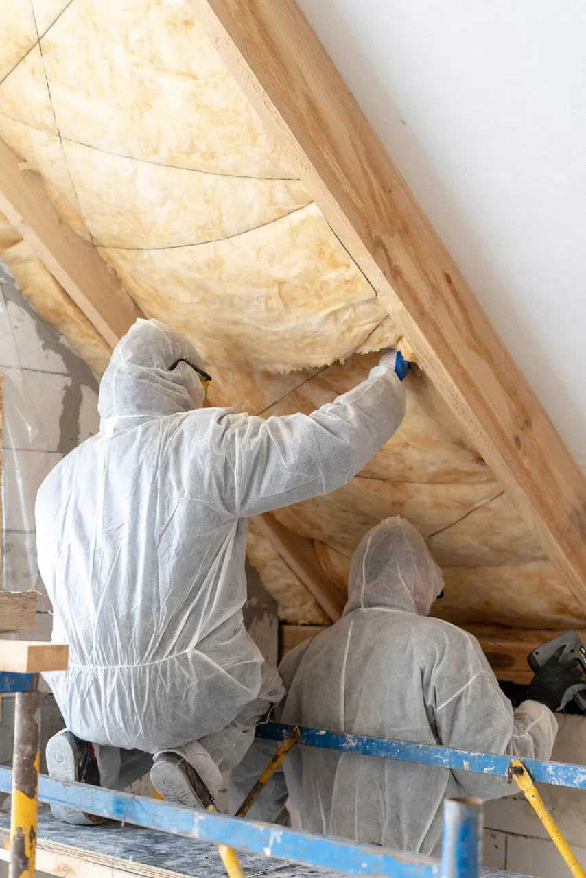  workers installing thermal insulation rock wool under the roof