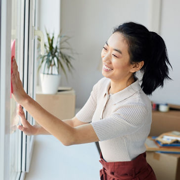 young  woman washing windows