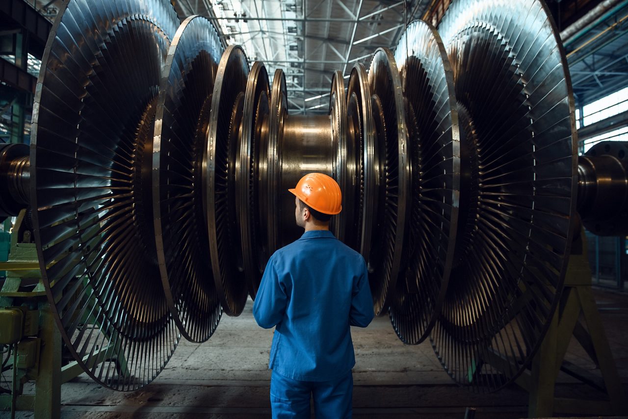 Man in overalls within machine parts