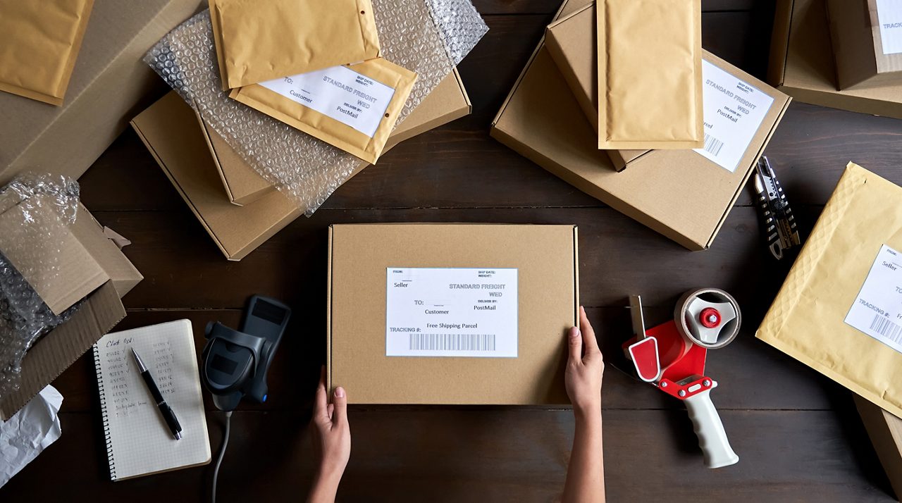 Person packing ecommerce shipping order package.
