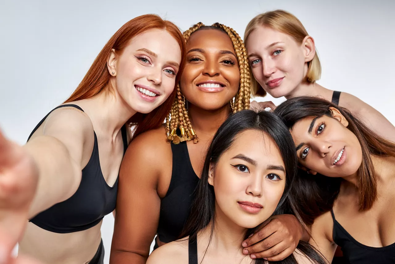 portrait of friendly interracial group of women models posing at camera 