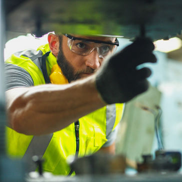 공장에서 안전 고글을 착용하고 장비를 점검하는 남성 작업자