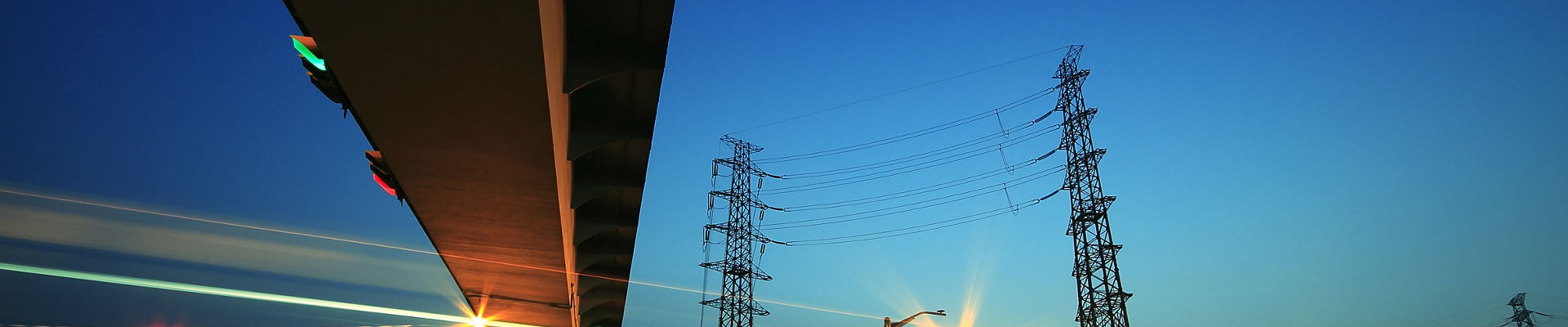 Long exposure of cars passing through city-highway and transmission tower