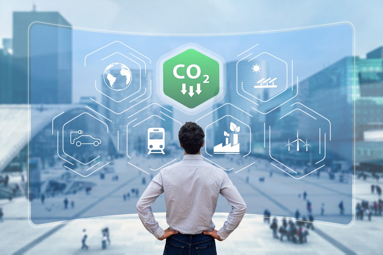CO2アイコンが緑色で表示される仮想画面を見る男性 