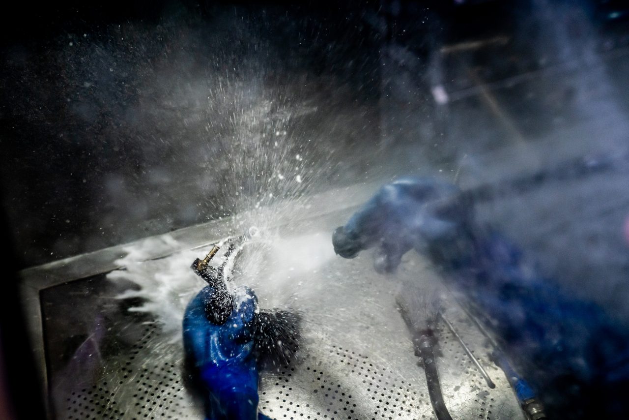 Person cleaning industrial parts