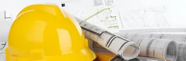 Yellow helmet, calculator, level and project drawings