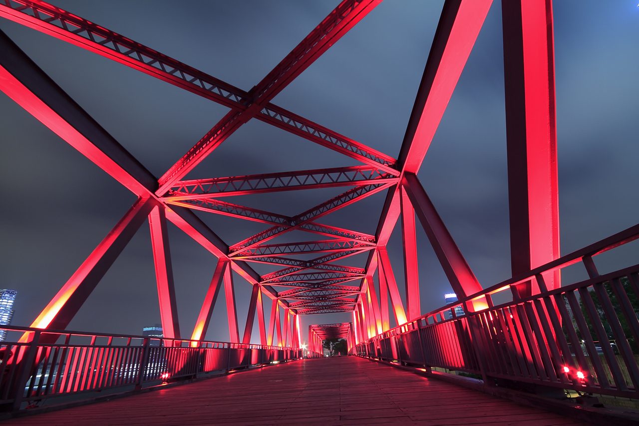 Puente de estructura de acero por la noche con un cielo nublado