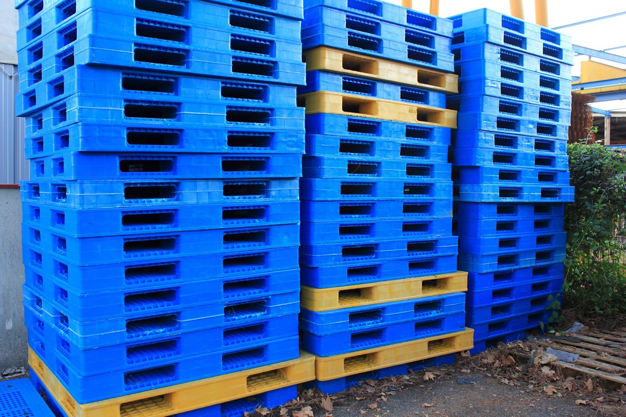 Three large stacks of blue and yellows pallettes