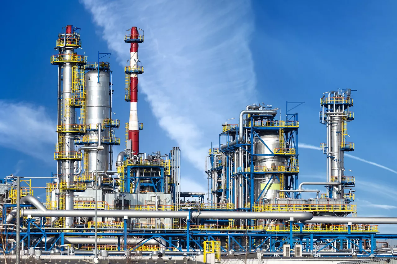 Petrochemical plant, oil refinery factory over blue sky.