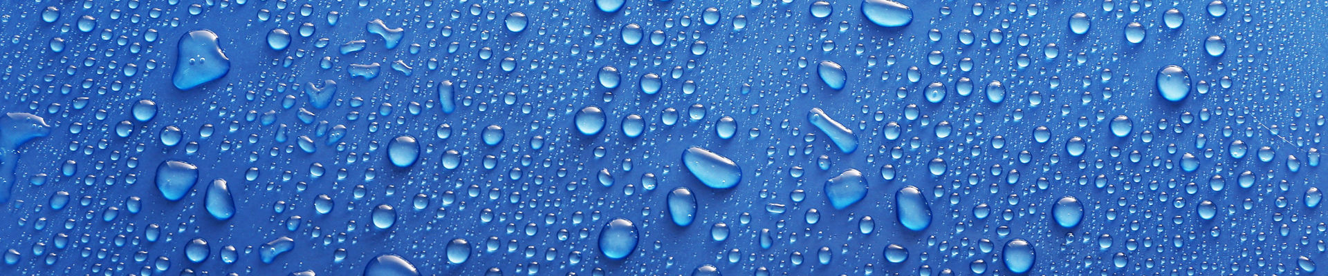 Water drops on glass on blue background.