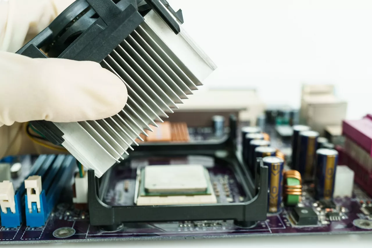 Latex gloved hand inserting plastic housing into circuit board