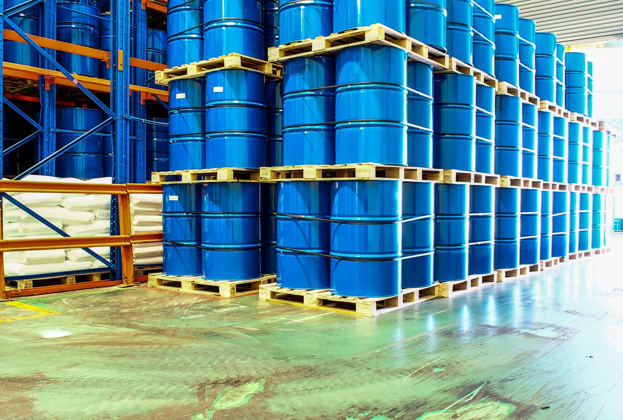 Blue industrial drums on warehouse shelves
