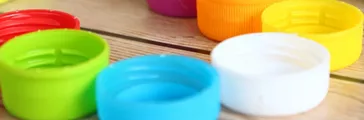 Colorful bottle caps on wooden background.