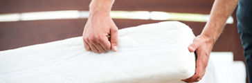 Close up photo of young man demonstrating quality of mattress