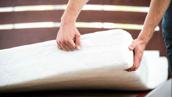 Close up photo of young man demonstrating quality of mattress