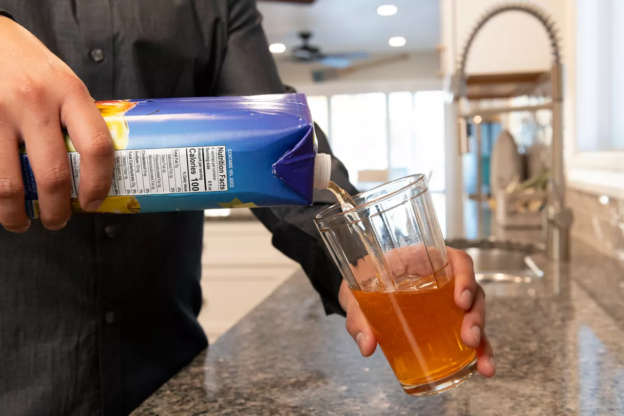Pouring juice from an apple carton container 