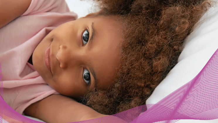 小女孩躺在面向床的相机、ConfortScience PURE 品牌元素和徽标中 