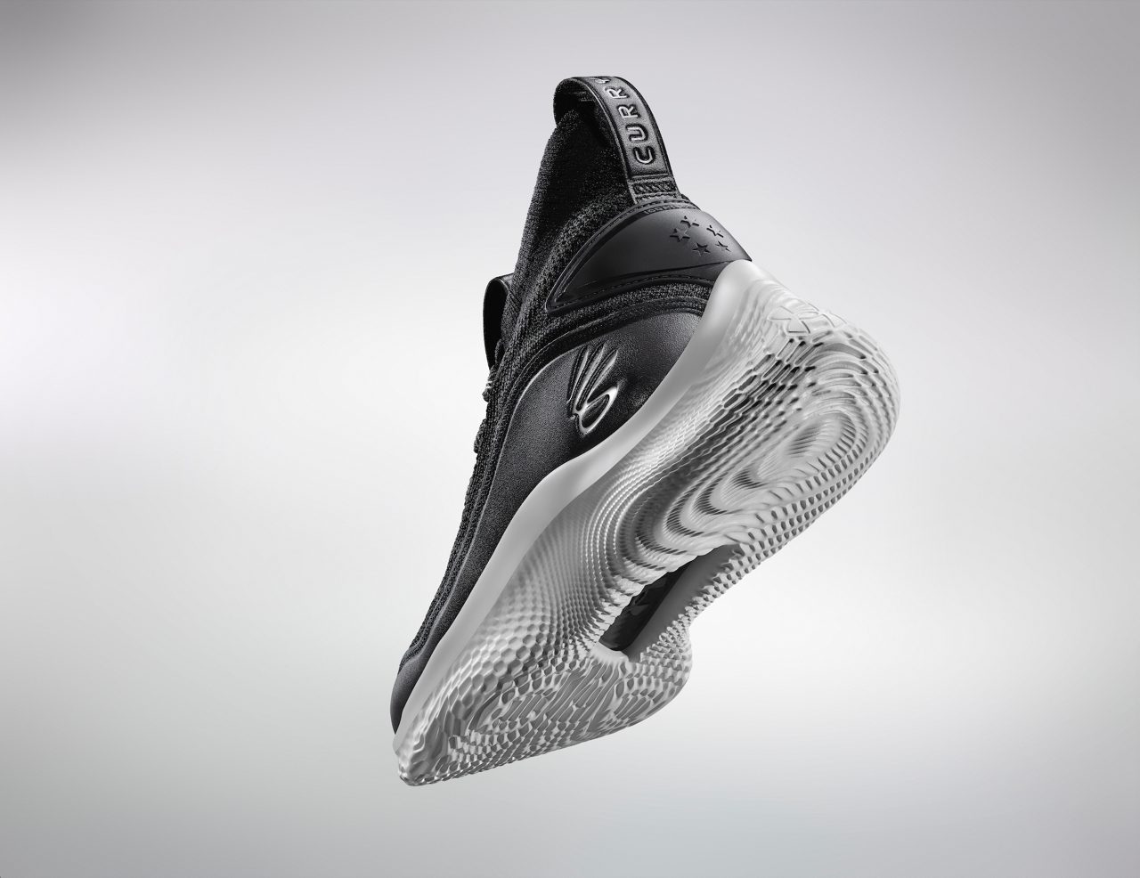 The Curry Flow 8 basketball shoe hovering on white background, with a focus on the sole of the shoe