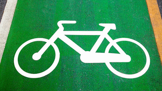 Bike lane signs painted onto a green bike lane