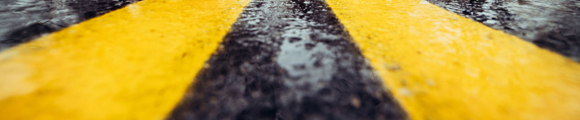 marca de carretera amarilla en asfalto húmedo