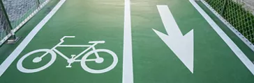 View of bicycles symbol and arrow marking on green bike lane. A Bike Lane is defined as a portion of the roadway that has been designated by striping, signage or exclusive use of bicyclists.