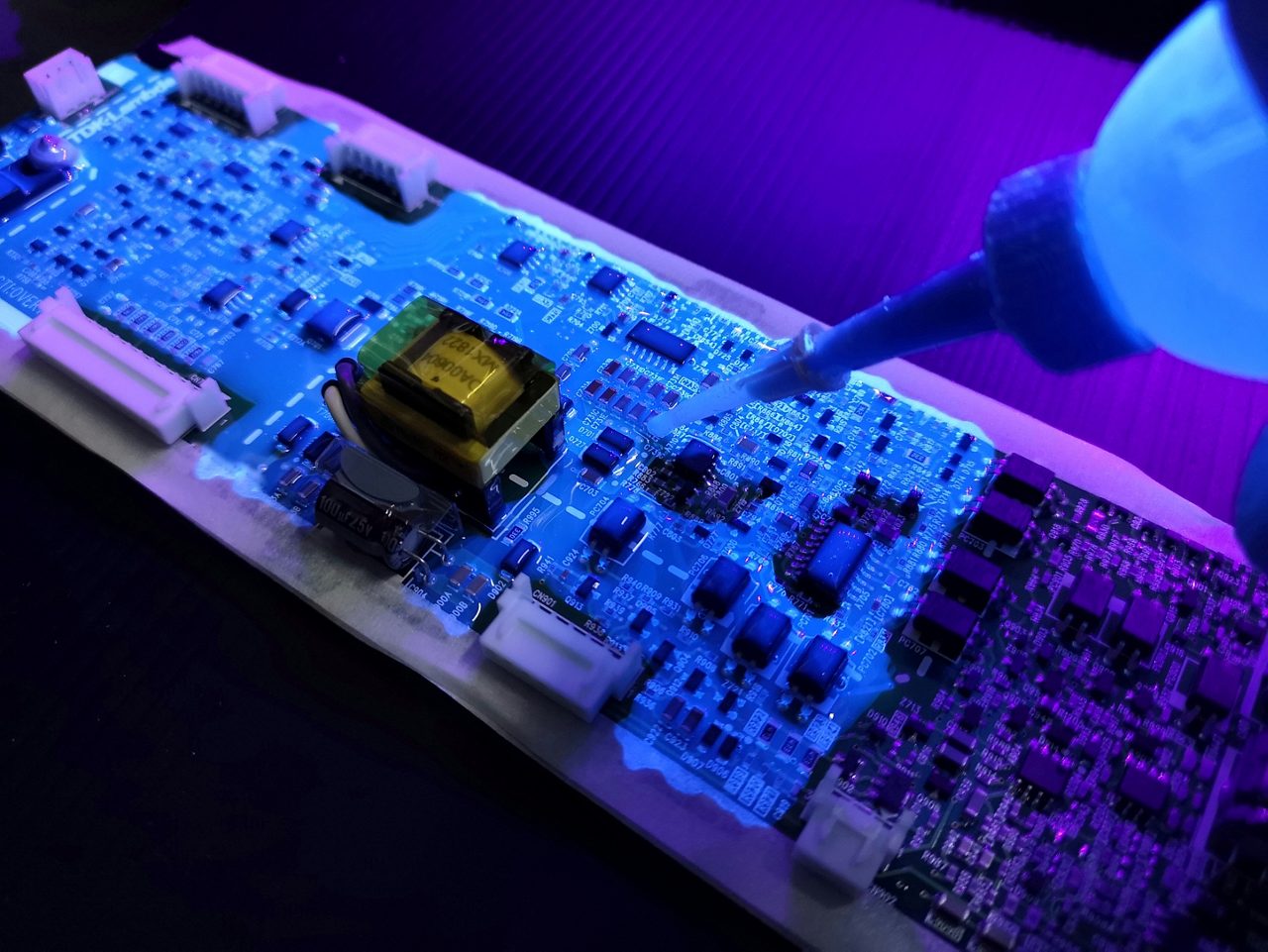 Conformal coating application on electronics board under UV light