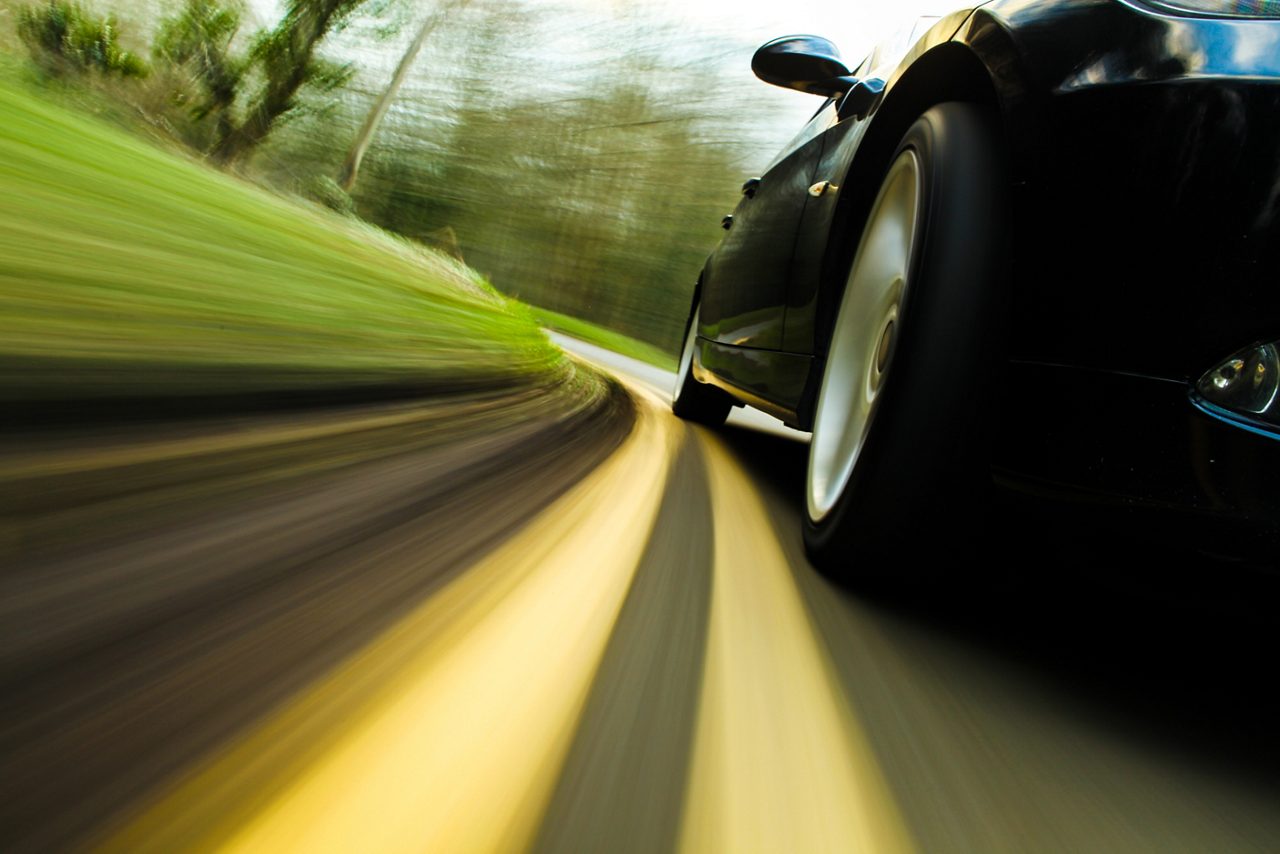 Front side view of black car in turn