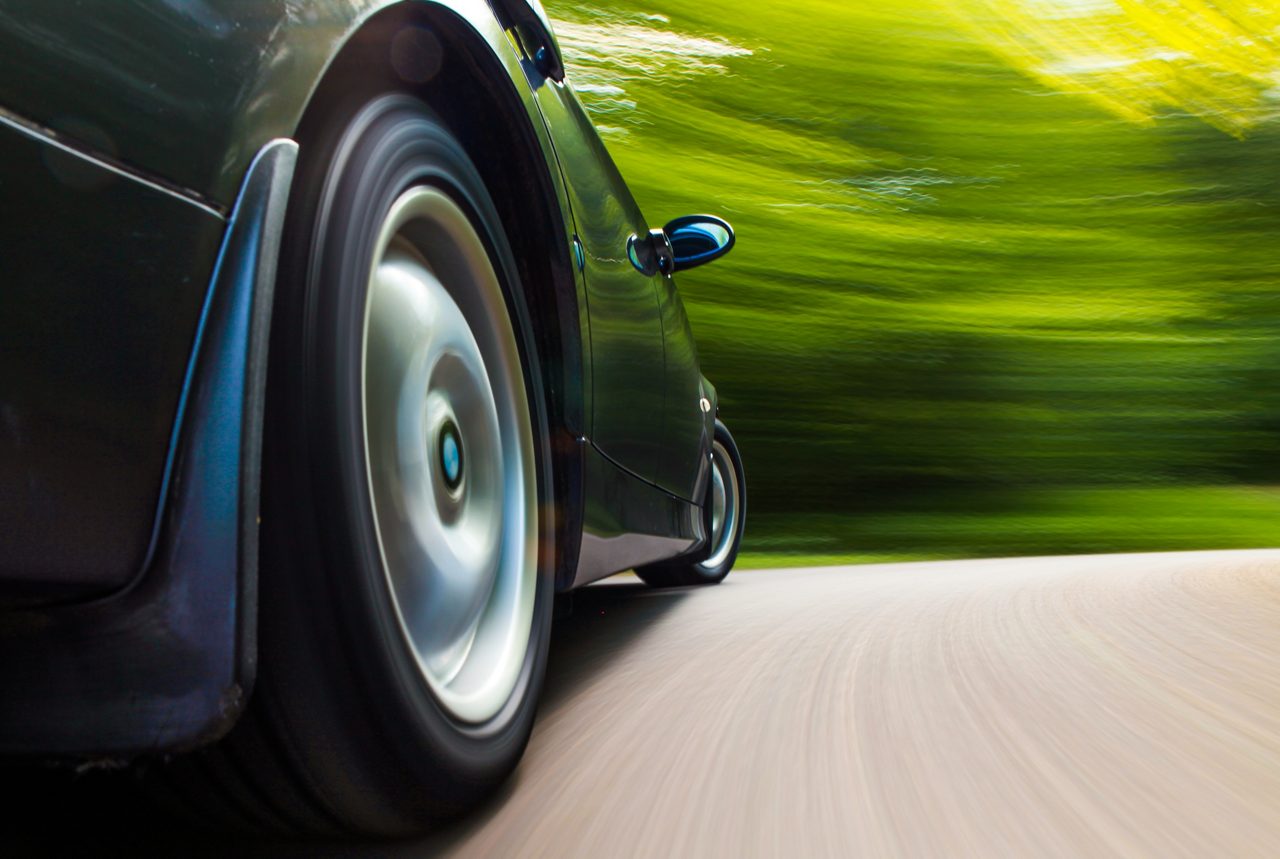 Rear side view of black car in turn with heavy blurred motion.