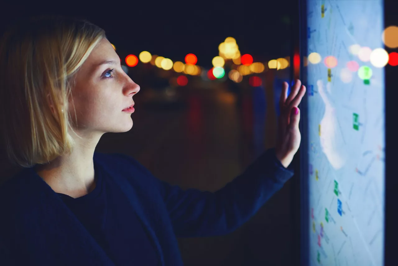 Young female tourist using smart city gadget to get direction