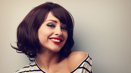 Closeup portrait of a young woman with short hair in fashion blouse and makeup