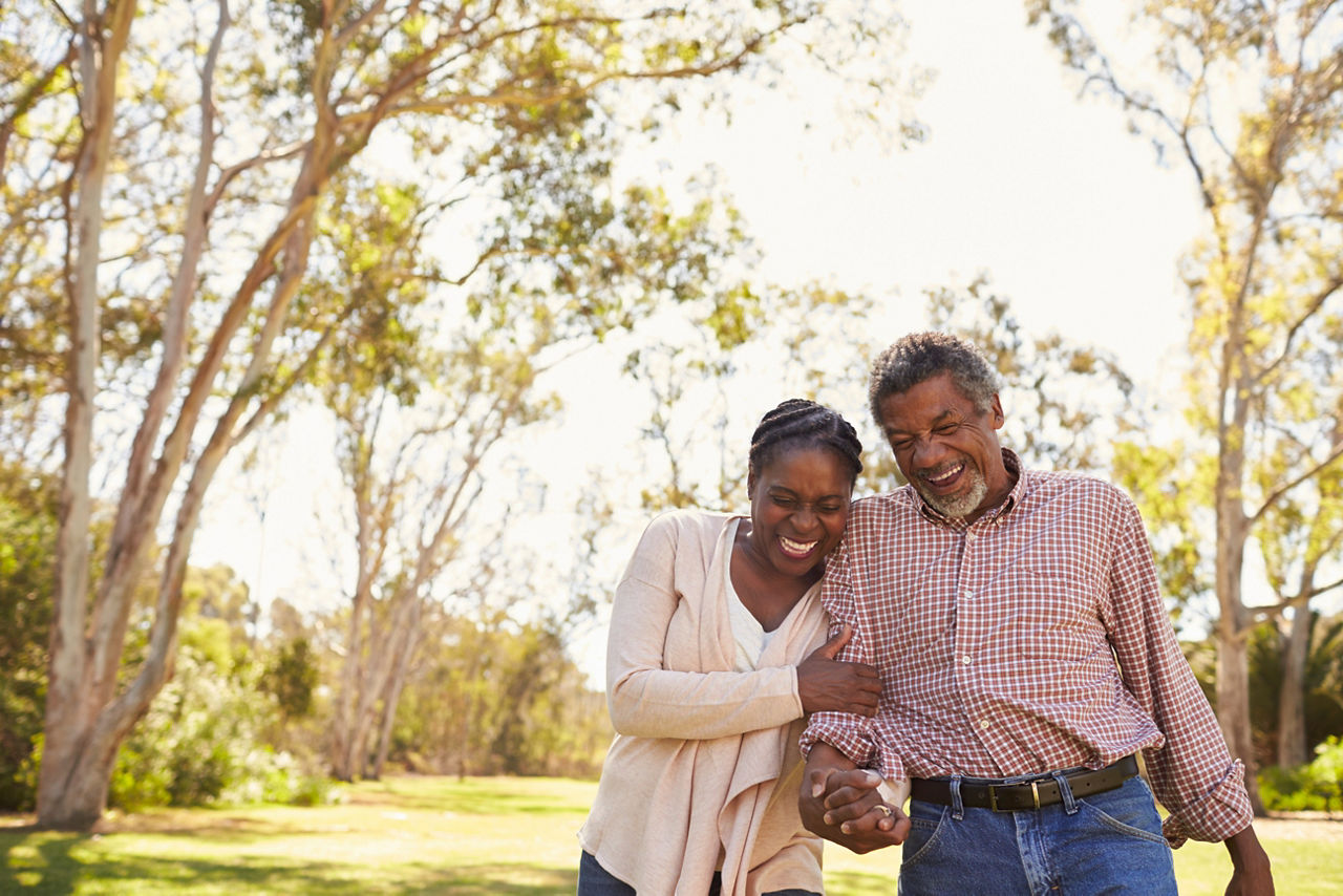Outdoor Shot Of Mature Couple Walking In Park Together