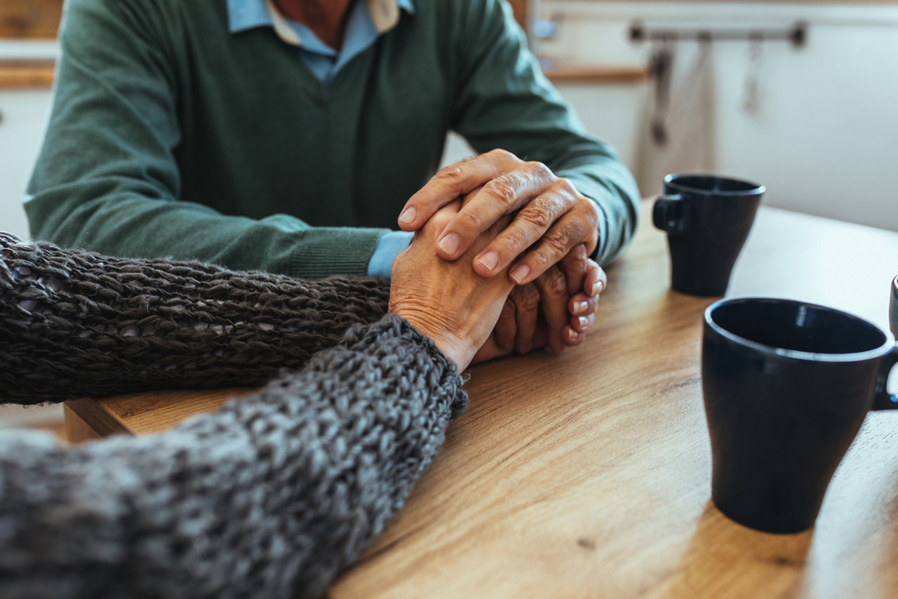 Senior couple holding hands closeup
