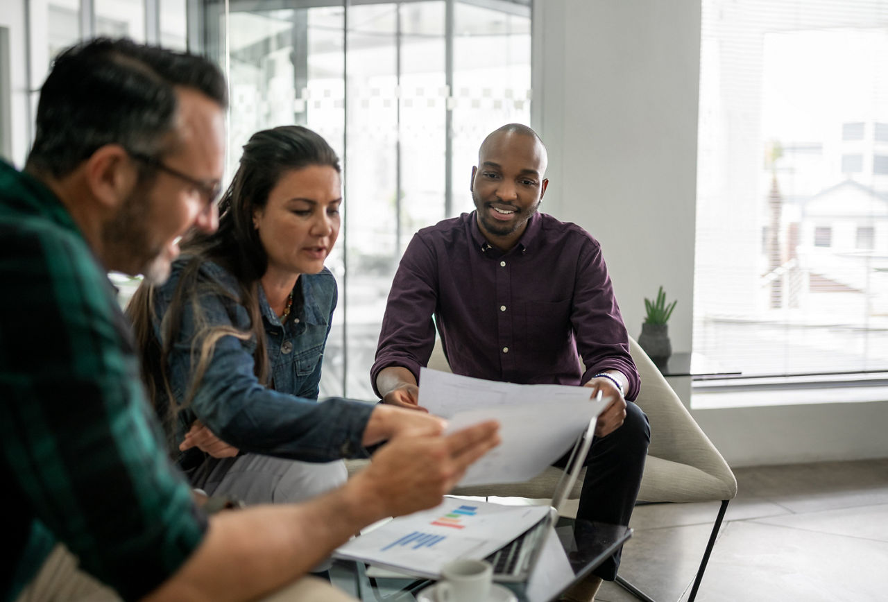 Casual meeting of diverse business team analyzing financial data