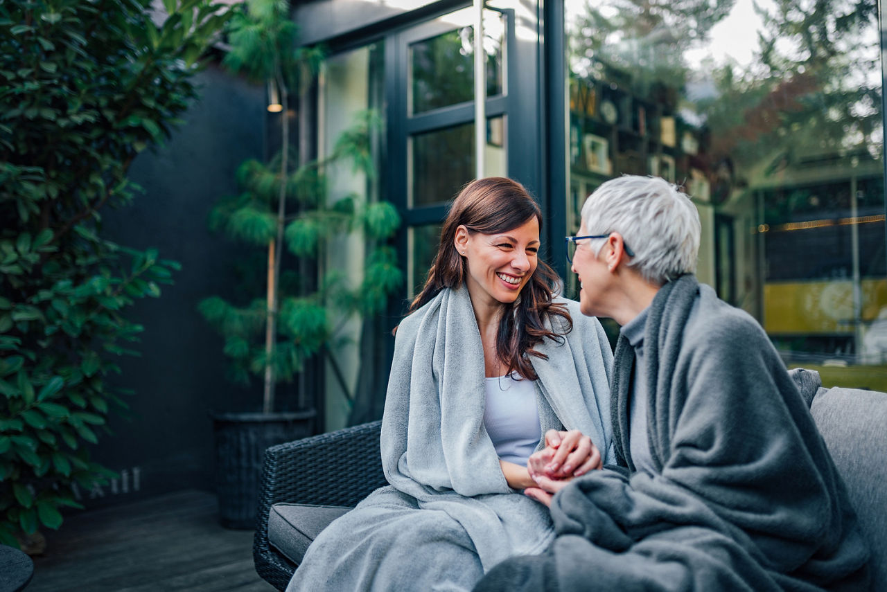 Beautiful mother and daughter spending time together in home garden, portrait.
