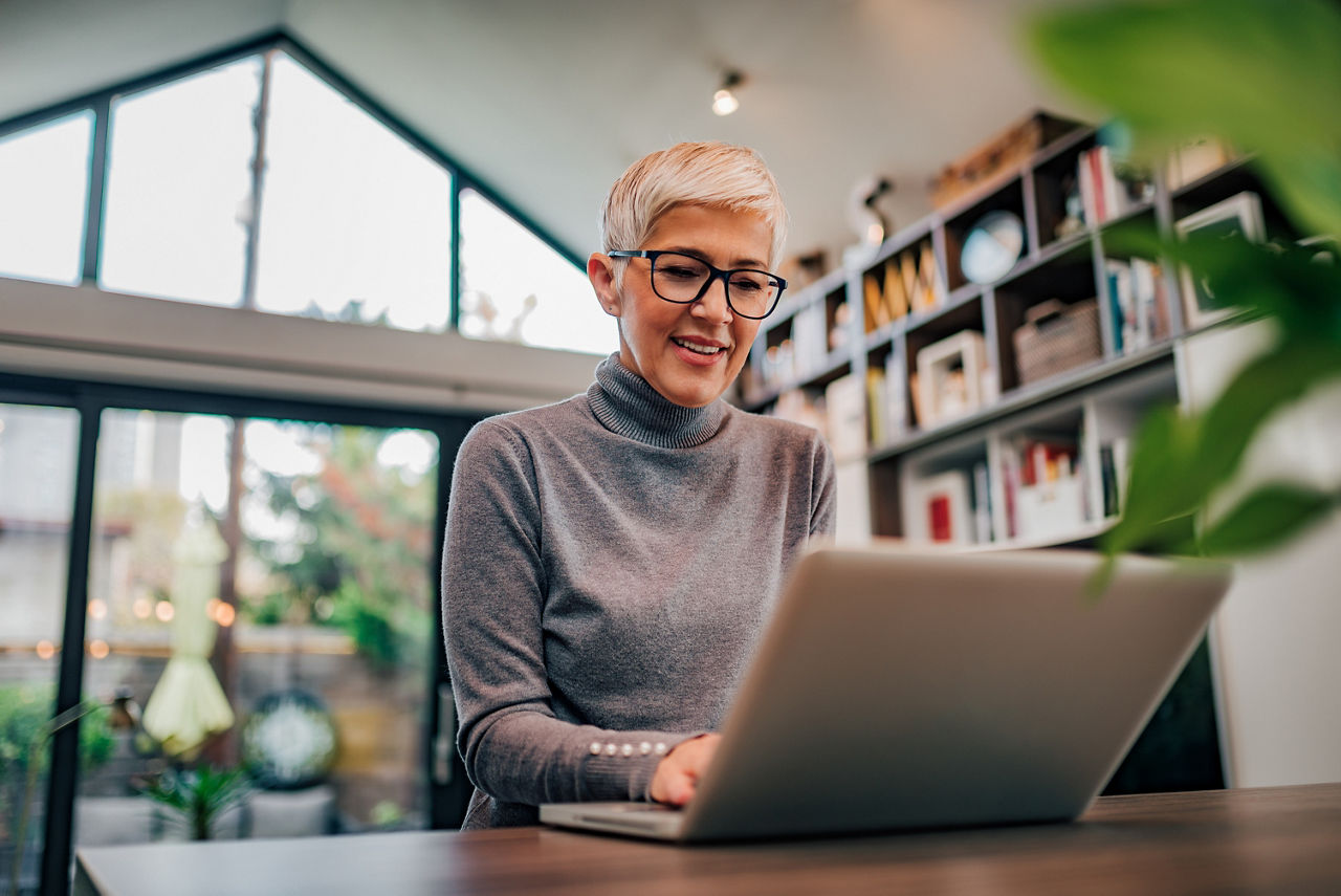 Portrait of a beautiful modern senior woman using laptop, low angle image.