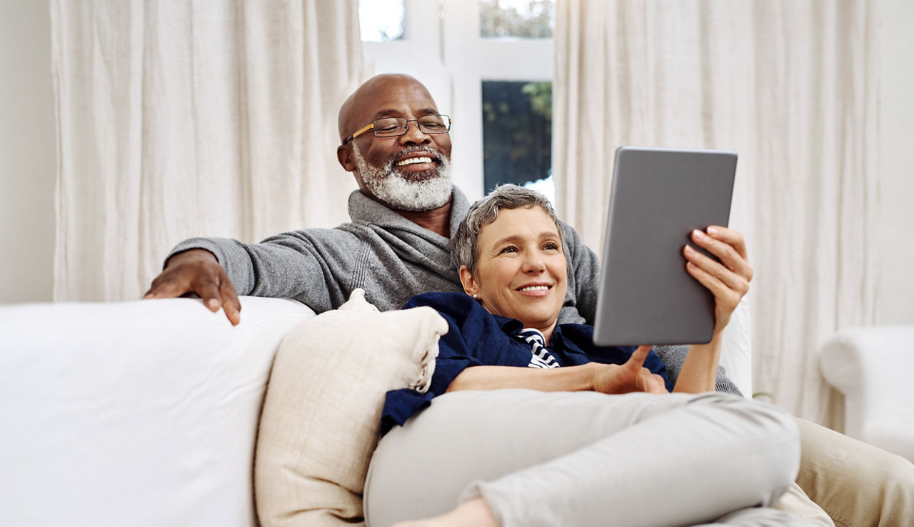 Shot of an affectionate senior couple using a tablet while relaxing on the sofa at home.