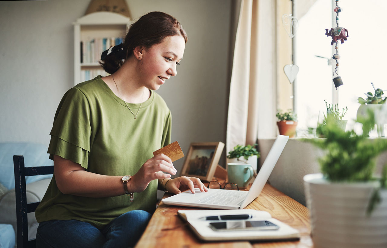 Cropped shot of an attractive young businesswoman sitting alone in her home office and using her laptop for online shopping.