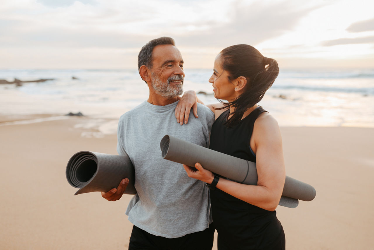 Positive senior caucasian family in sportswear with mat enjoy workout and active lifestyle on beach in morning, outdoor. Love, relationships, sports together, yoga and fit at summer