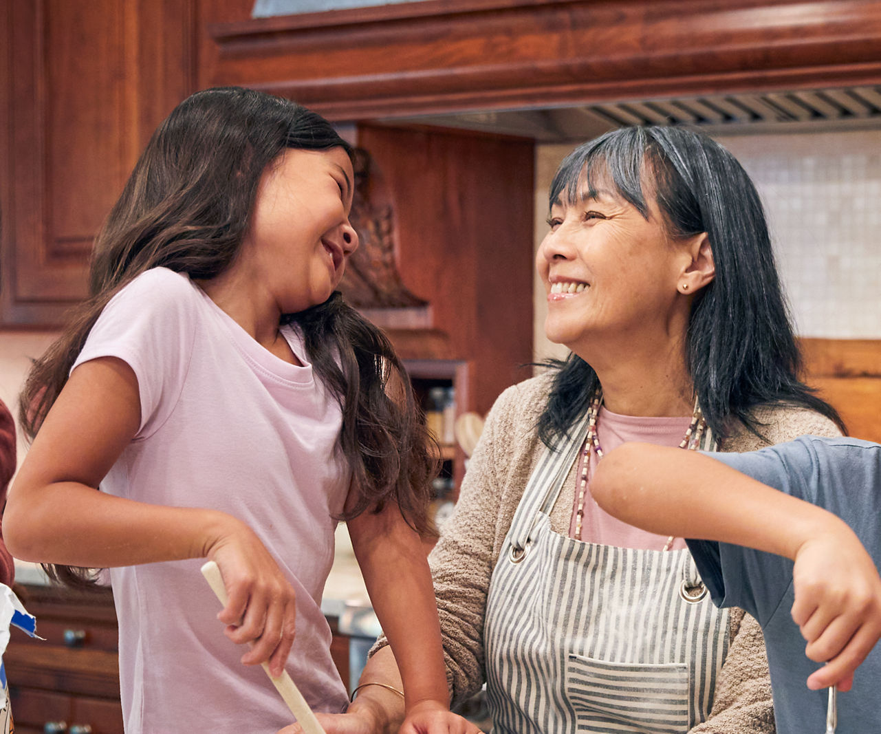 A family making food together around a kitchen island.