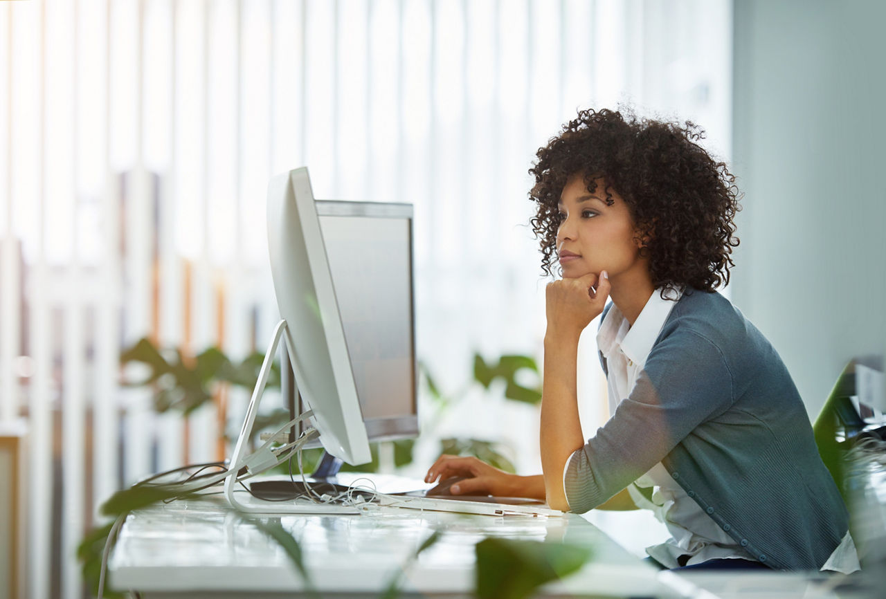 Shot of a young designer deep in thought while working on a computer in a modern office