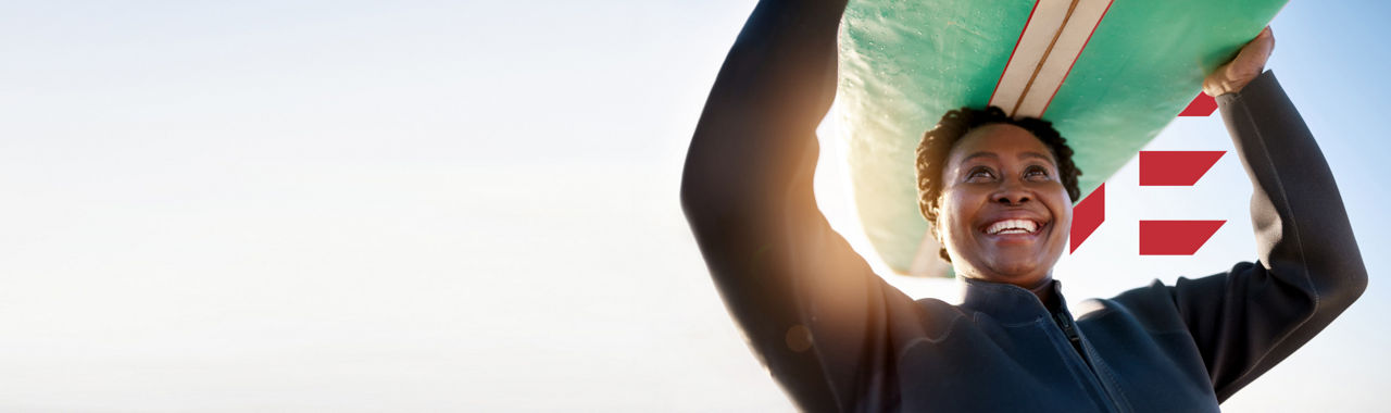 Smiling woman brings carries her canoe overhead