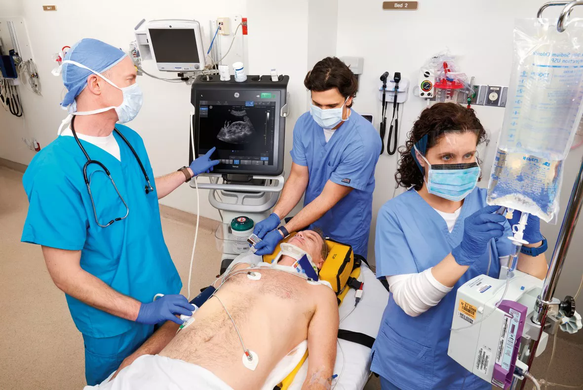Three doctors working on a patient