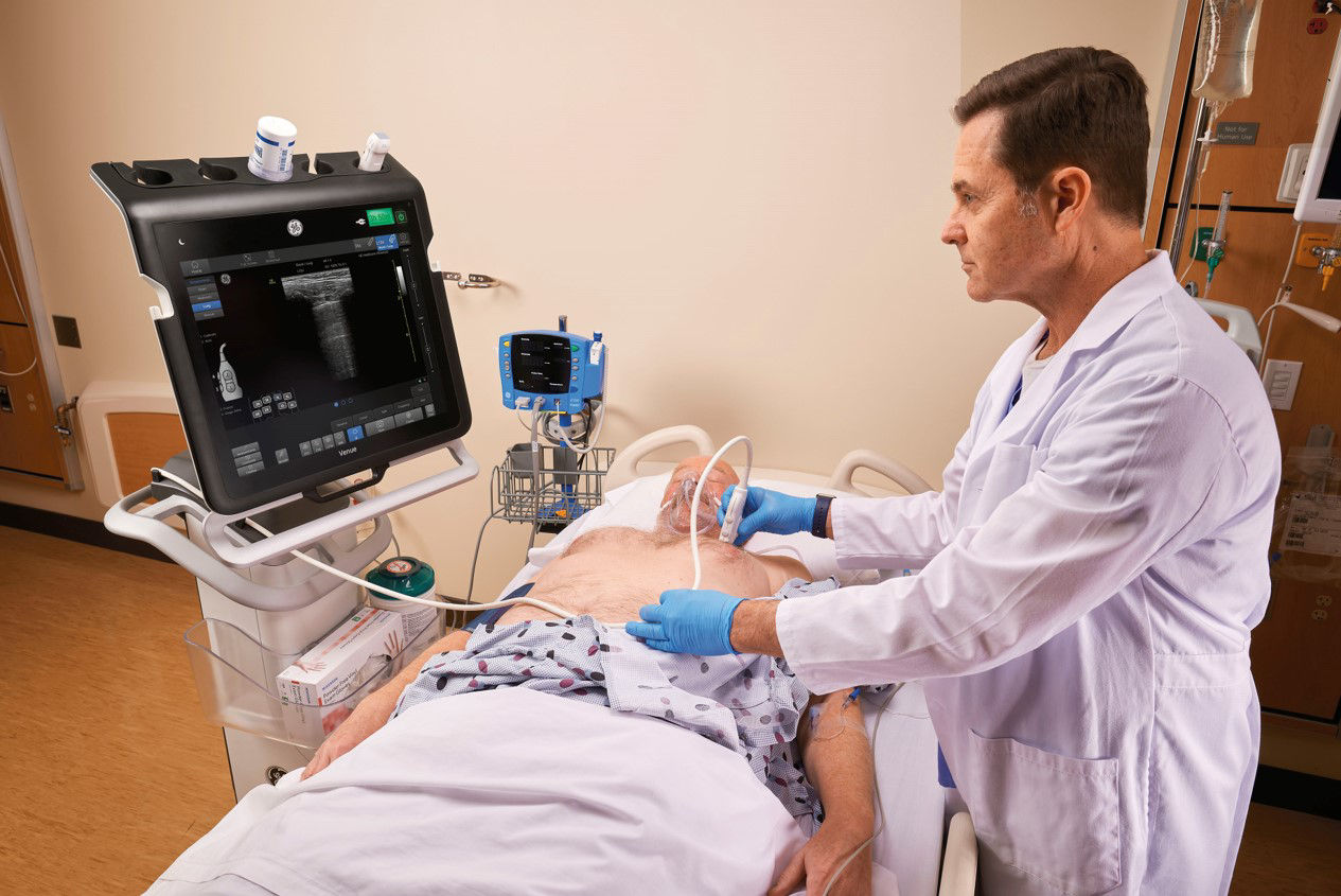 One doctor working on a patient looking at a Venue monitor