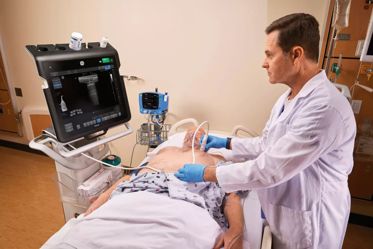 One doctor working on a patient looking at a Venue monitor
