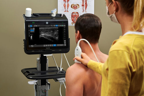 ultrasound tech using a probe to examine a patient with musculoskeletal concerns