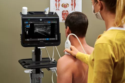 ultrasound tech using a probe to examine a patient with musculoskeletal concerns