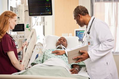 Clinicians moving an intubated patient.