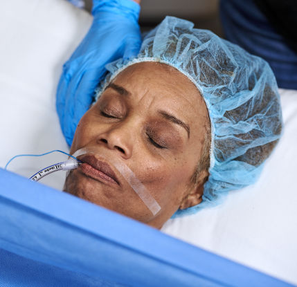 Two clinicians performing laparoscopic surgery on a patient