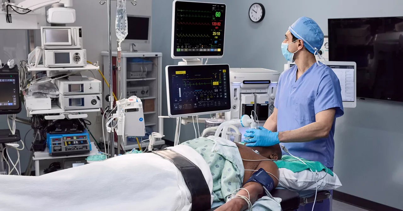 a medical professional using GEHC's Aisys CS² anesthesia delivery system with ET Control in an operating room